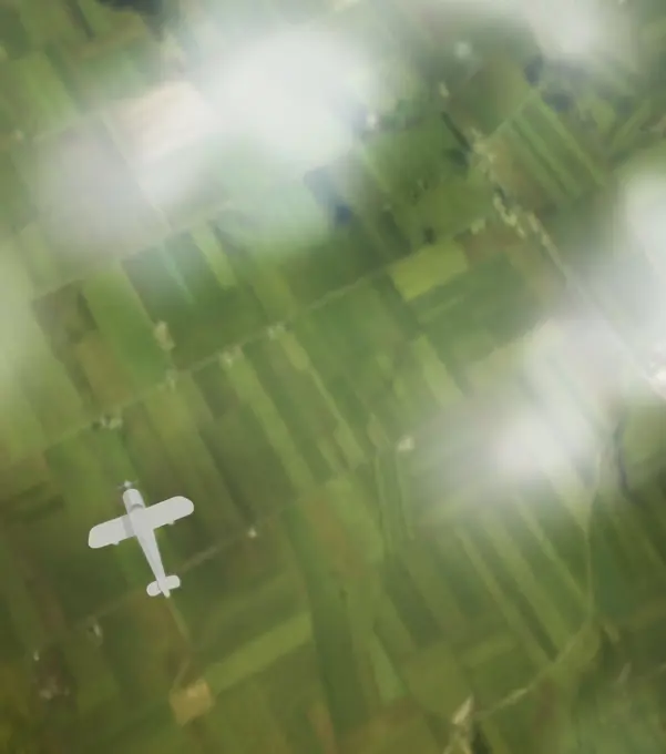 Overhead view of plane flying over green landscape