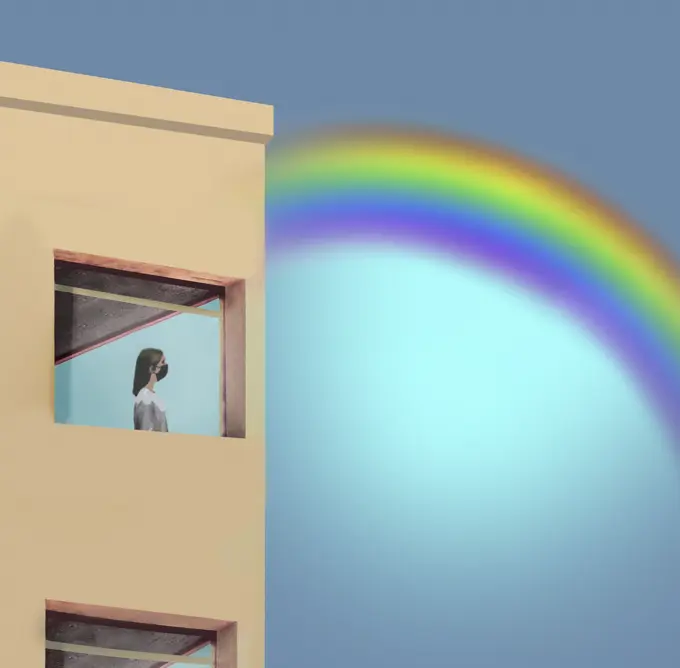 Woman in lockdown looking at rainbow through window