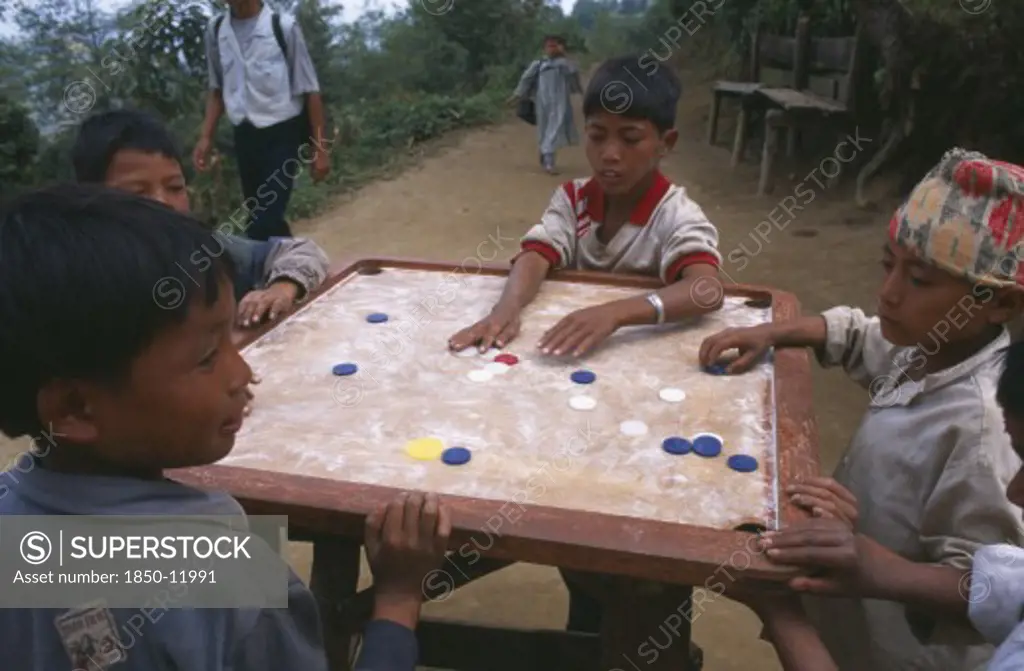 Nepal, Dhankuta Region, Children, Limbu Boys Playing Karem Board Game.