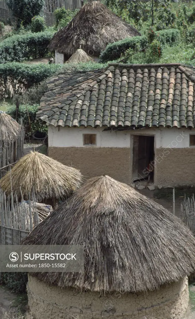 Rwanda, Gishwati, Rondavel Thatch Next To More Modern Tiled Roof Home.