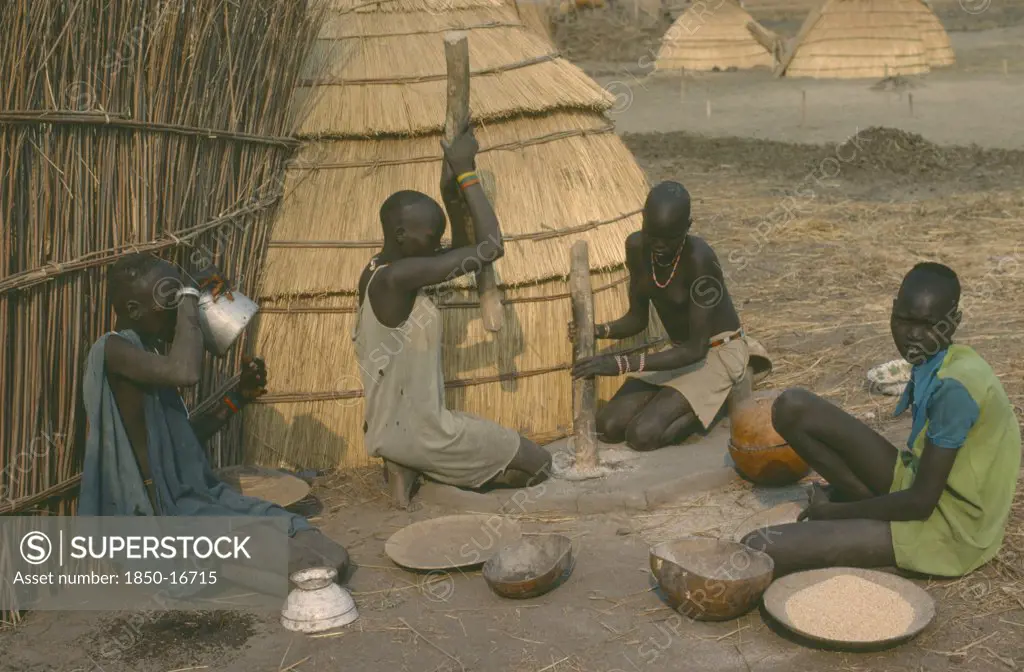 Sudan, Agriculture, Dinka Women Pounding Millet Outside Their Hut.