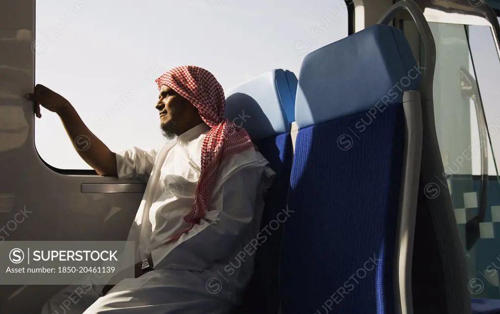 United Arab Emirates, Dubai, Arab male in Dishdasha on Dubai Metro train.