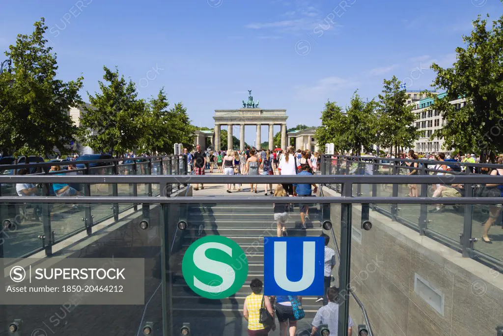 Germany, Berlin, Mitte, sightseeing tourists emerging from the U-Bahn and S-Bahn station on Unter den Linden and walking towards Brandenburg Gate or Brandenburger Tor.-