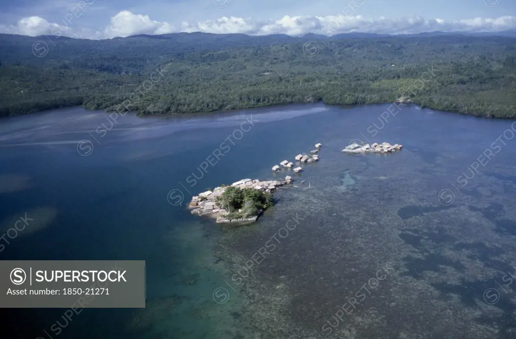 Pacific Islands, Melanesia, Solomon Islands, 'Malaita Province, Lau Lagoon, Foueda Island.  Aerial View Over Artificial Man Made Island And Houses With Mainland Covered By Dense Forest Beyond. '