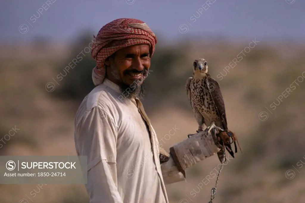 Saudi Arabia, Bedouin, Falconry, Bedouin Man Holding Falcon On His Wrist.