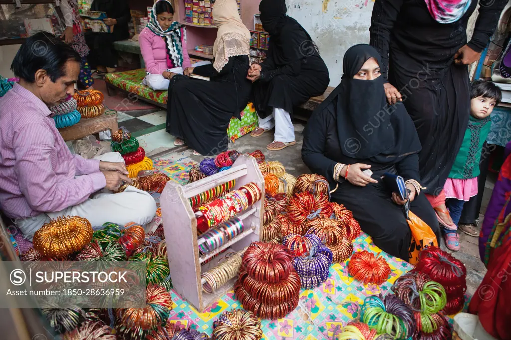India, Uttar Pradesh, Faizabad, Muslim women buying bangles in a shop in .