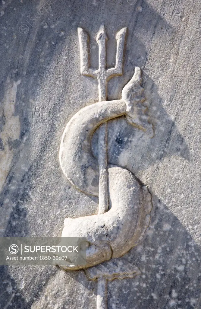 Greece Attica Athens, Close cropped view of stone carving of sea creature curved around trident