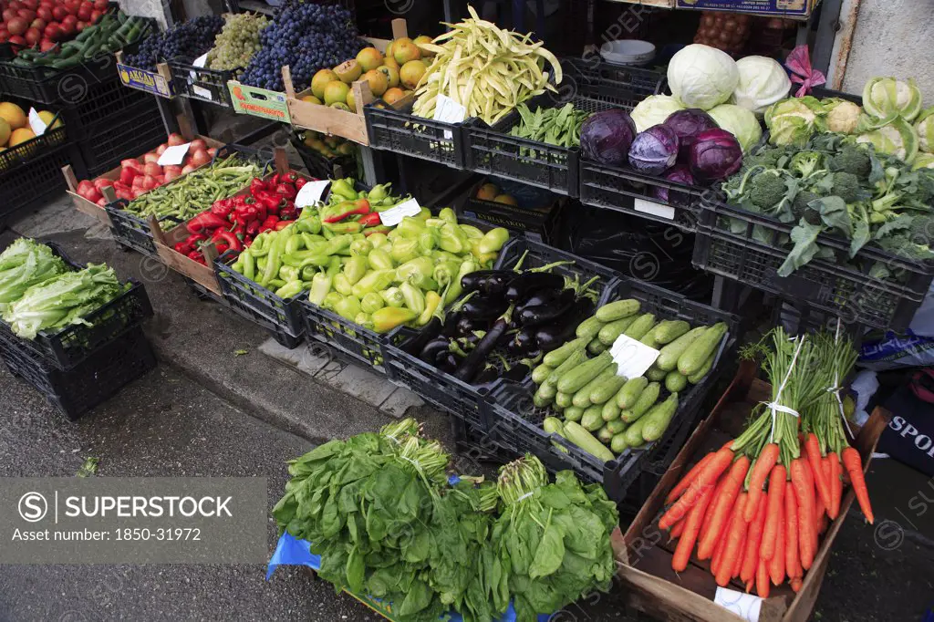 Albania, Tirane, Tirana, Display of fruit and vegetables at grocers stall in the Avni Rustemi Market including aubergines  cabbage and carrots.