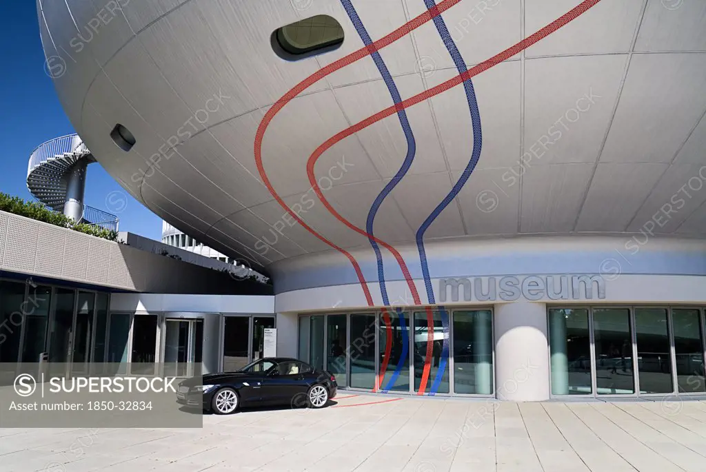 Germany, Bavaria, Munich, BMW Headquarters, The BMW Museum, Entrance with car outside.