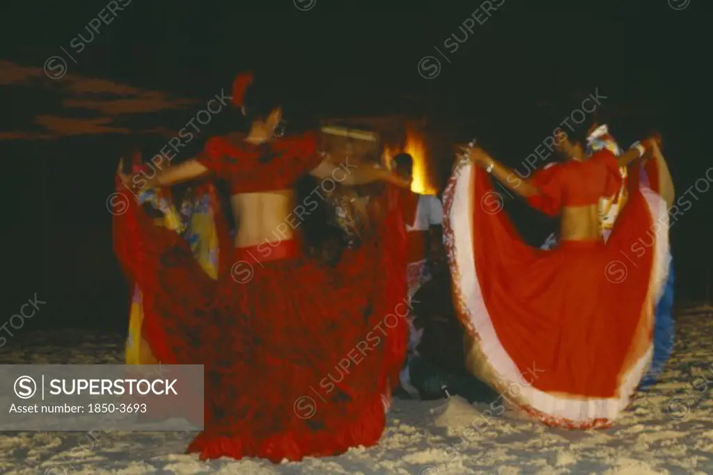 Mauritius, Sega Dancers, Women In Red Costume Dancing On The Beach At Night.  Sega Is The National Dance And Musical Form Of Mauritius.