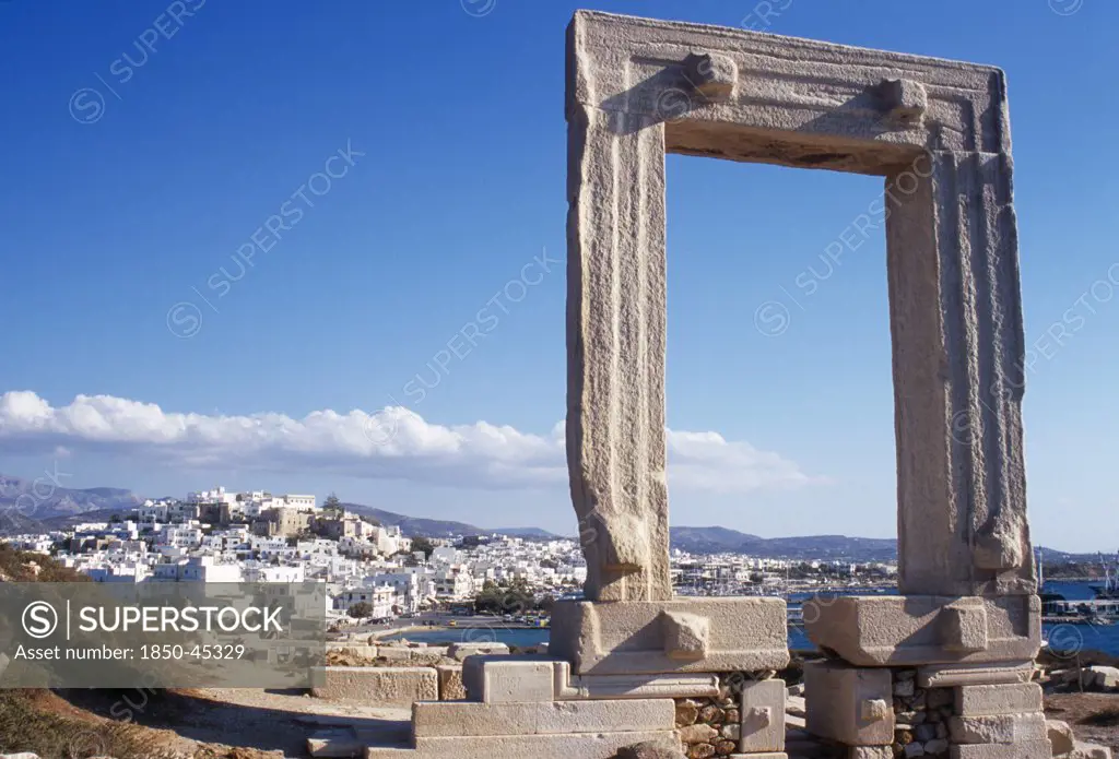 Naxos. Ruins of temple and the Portara Gateway marble doorway framing view of white painted Naxos Town below.Greece Aegean Islands Cyclades