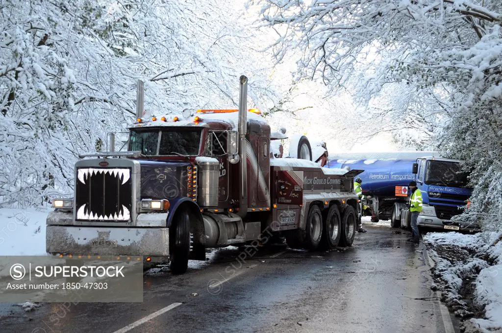 Weather, Winter, Snow, Recovery truck extracting a Jack-knifed fuel tanker on icy A22 main road near Nutley East Sussex after heavy snowfall.