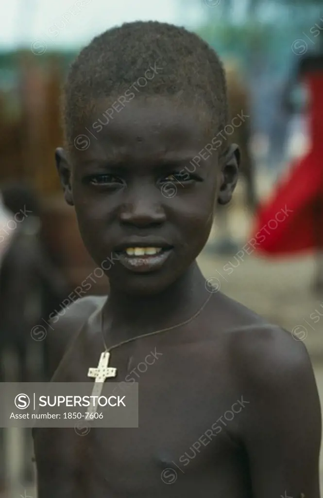 Sudan, South, Kongor, Dinka Boy.  Head And Shoulders Portrait Wearing Cross On String Around Neck.