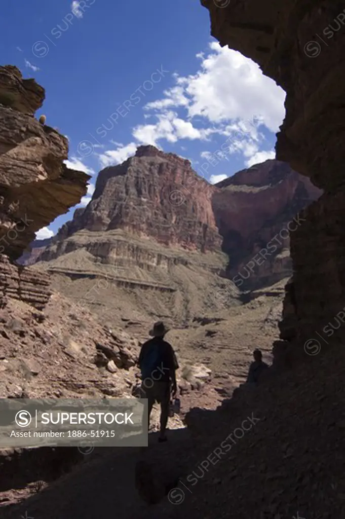 Hiker at the mouth of the Tapeats sandstone slot canyon of DEER CREEK at mile 136  - GRAND CANYON NATIONAL PARK, ARIZONA