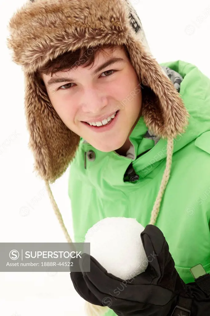 Teenage Boy Holding Snowball Wearing Fur Hat