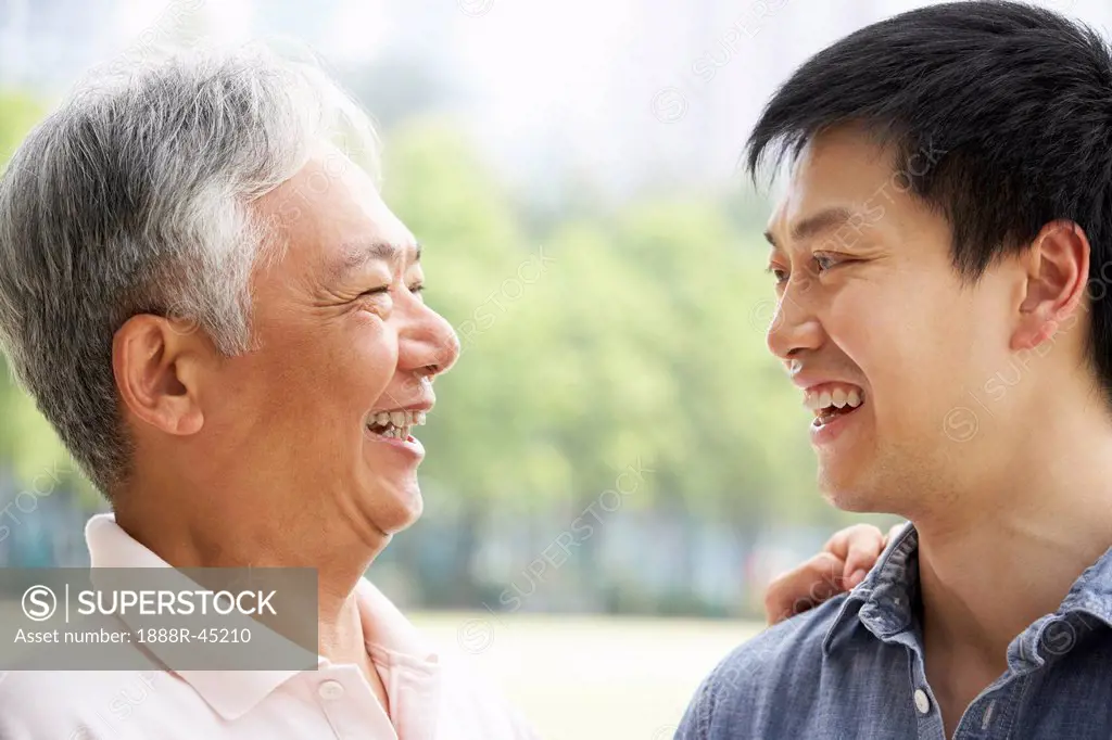 Portrait Of Chinese Father With Adult Son In Park