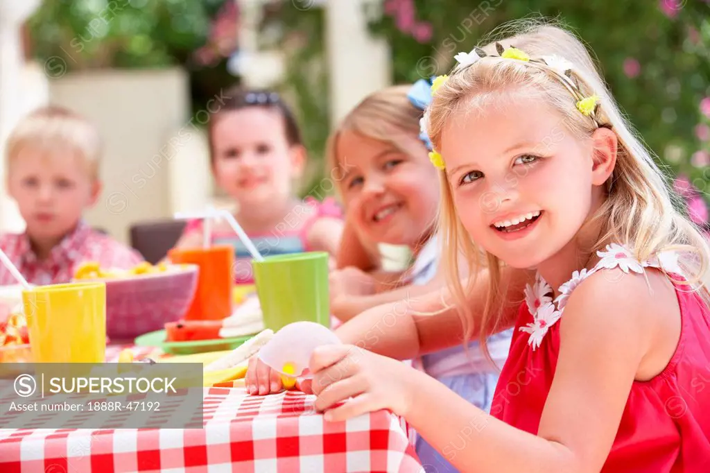 Group Of Children Enjoying Outdoor Tea Party