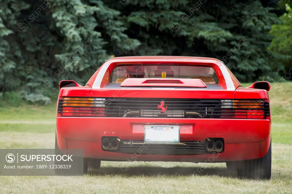 Red Ferrari Testarossa seen from the rear with exhaust fumes; Calgary, Alberta, Canada