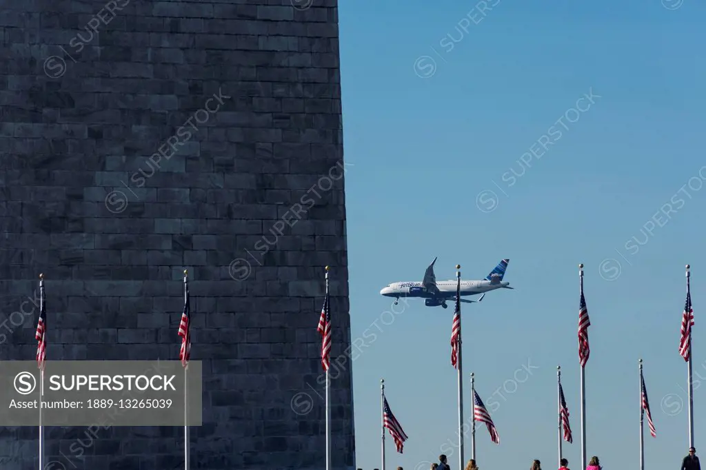 A jetBlue Airbus A320E aircraft with winglets (sharklets) flies by the Washington Monument on way to land at Reagan National Airport; Washington, Dist...