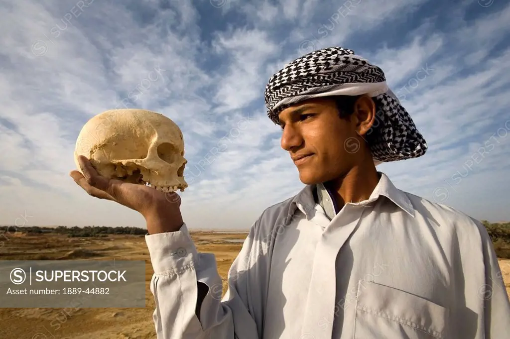 Young man holding human skull