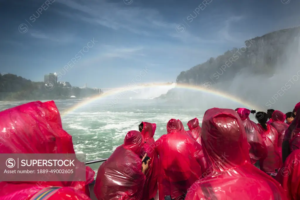 Tourists on a boat wearing red ponchos and viewing Niagara Falls; Niagara Fall, Ontario, Canada