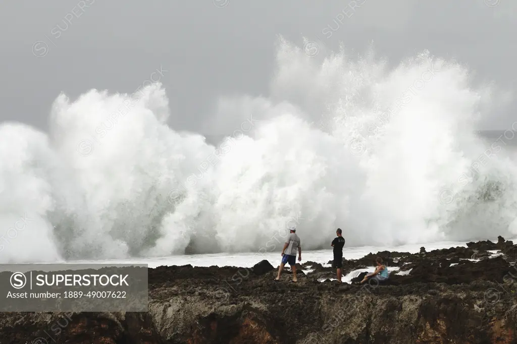 USA, Hawaii, Oahu, people watching; North Shore, Wave crashing against shore of Pacific ocean