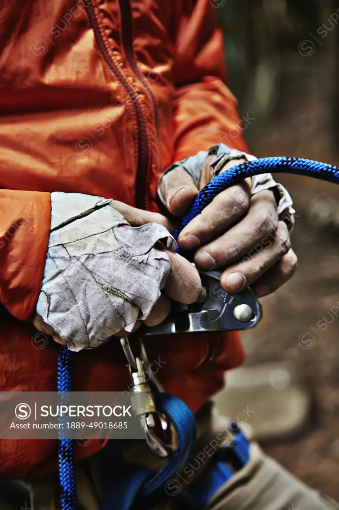 Man Adjusting Rock Climbing Equipment In The Adirondacks; New York, USA