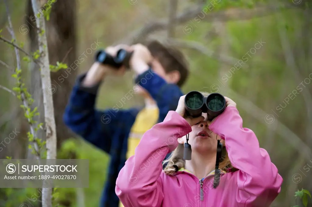 Siblings birdwatching with binoculars; Peru, Nebraska, United States of America