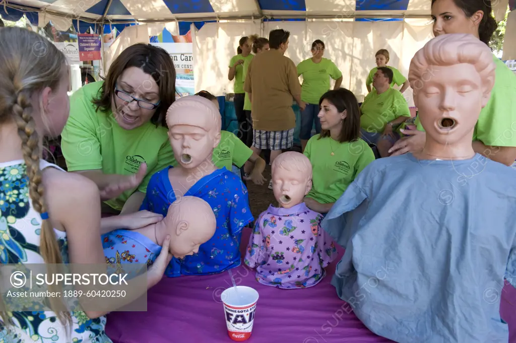 Woman teaches how to perform the Heimlich maeuver at a booth; Saint Paul, Minnesota, United States of America