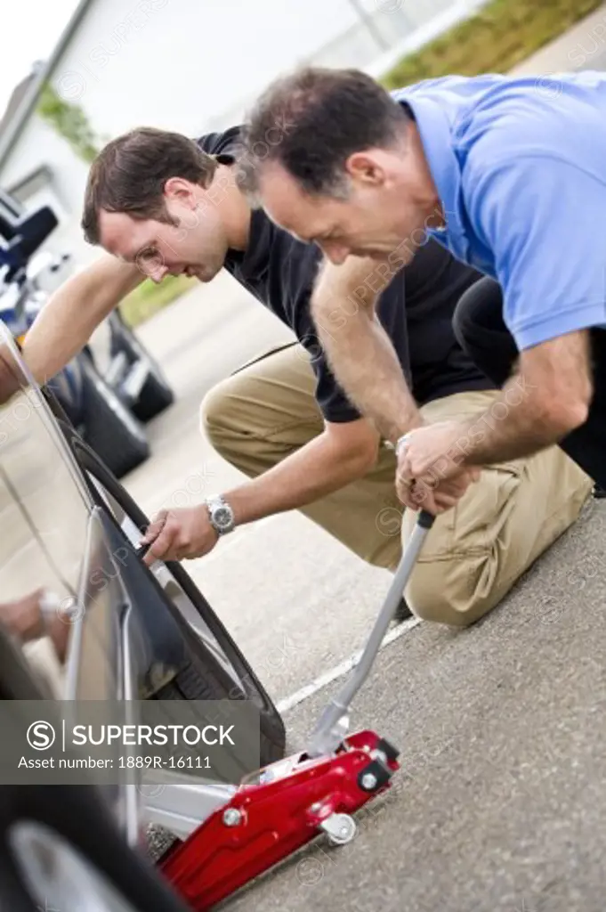 Two men fixing a flat tire