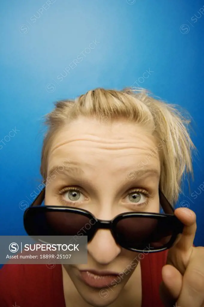 Woman wearing sunglasses with humorous facial expression