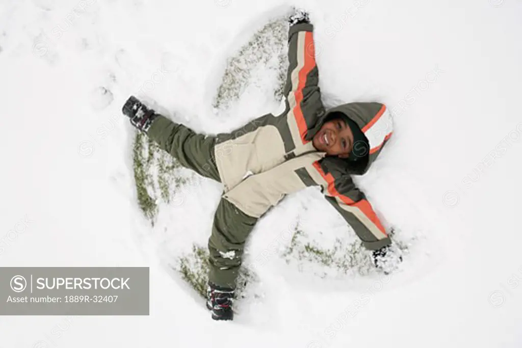 High angle view of a boy lying on snow