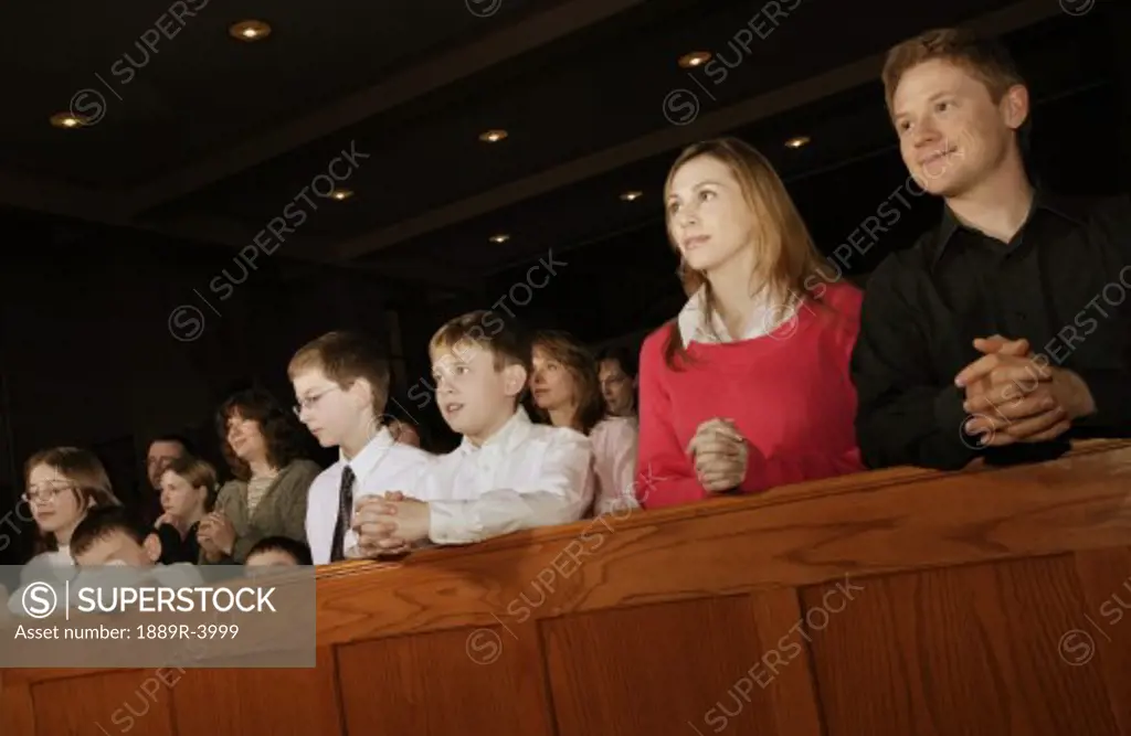 Catholic people kneeling in pew