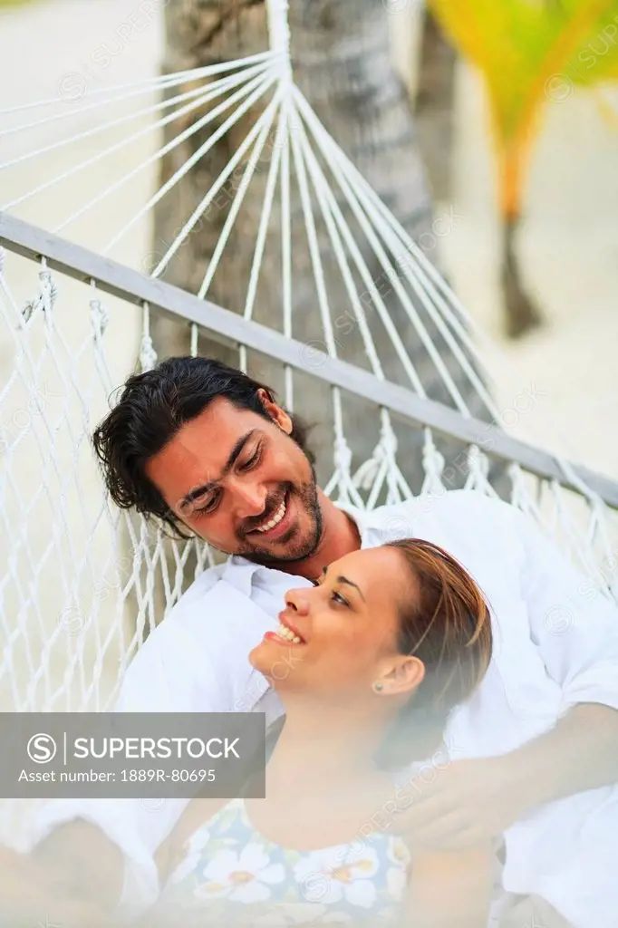 A man and woman in a hammock at the bora bora nui resort and spa, bora bora island society islands french polynesia south pacific