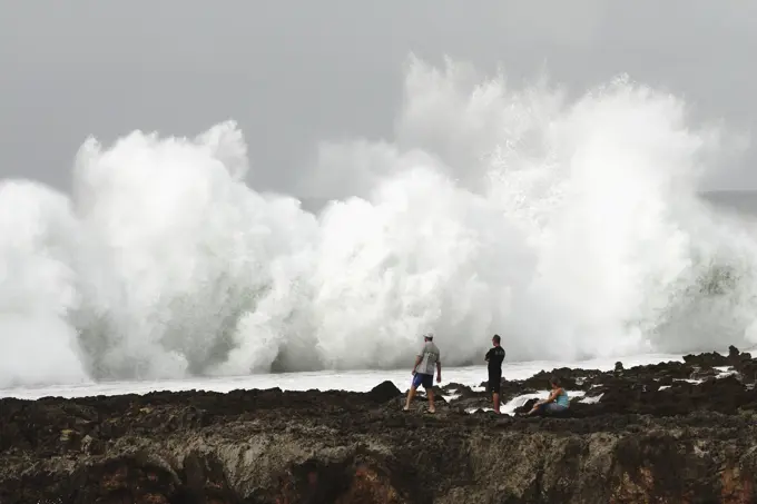 USA, Hawaii, Oahu, people watching; North Shore, Wave crashing against shore of Pacific ocean