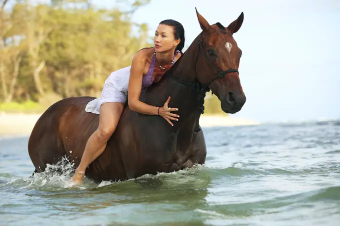 Hawaii, Oahu, North Shore, Woman Posing On Horse In Ocean.