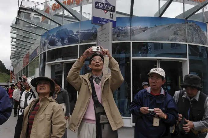 Japanese tourists gather at the main plaza to view the Matterhorn, Switzerland