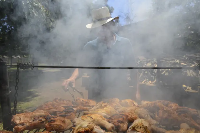 Man in smoke over a large barbecue in Chile; Santiago de Chile, Chile