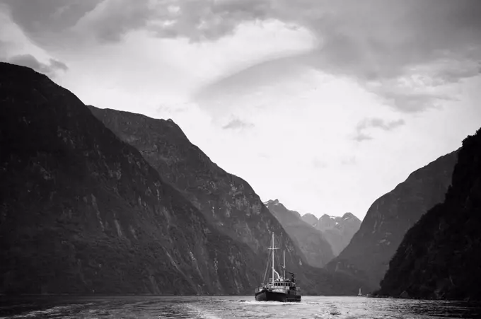 A Boat Travels Through A Waterway Between The Mountains, Milford Sound South Island New Zealand