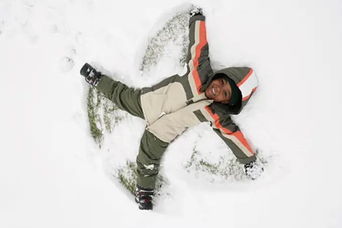 High angle view of a boy lying on snow