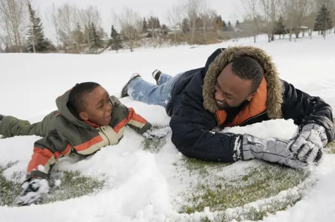 Father and son playing on snow