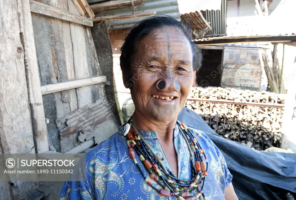 Apatani tribal woman with traditional yaping hullo (nose plugs) and facial tiipe (tatooing) and a crucifix, Arunachal Pradesh, India, Asia