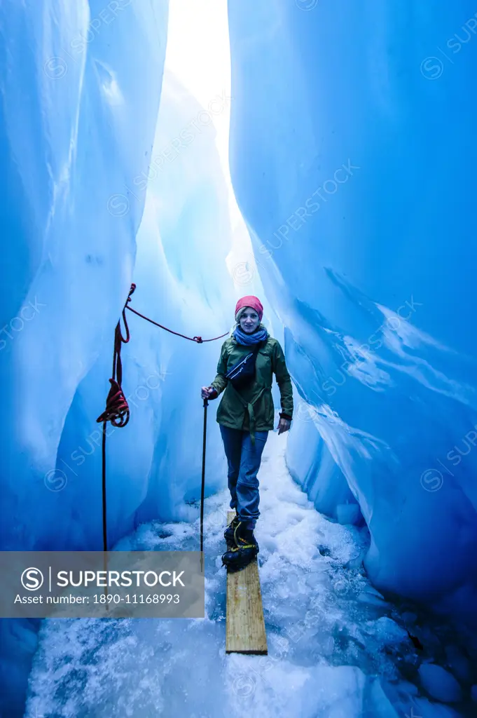 Woman standing in an ice cave, Fox Glacier, Westland Tai Poutini National Park, South Island, New Zealand, Pacific