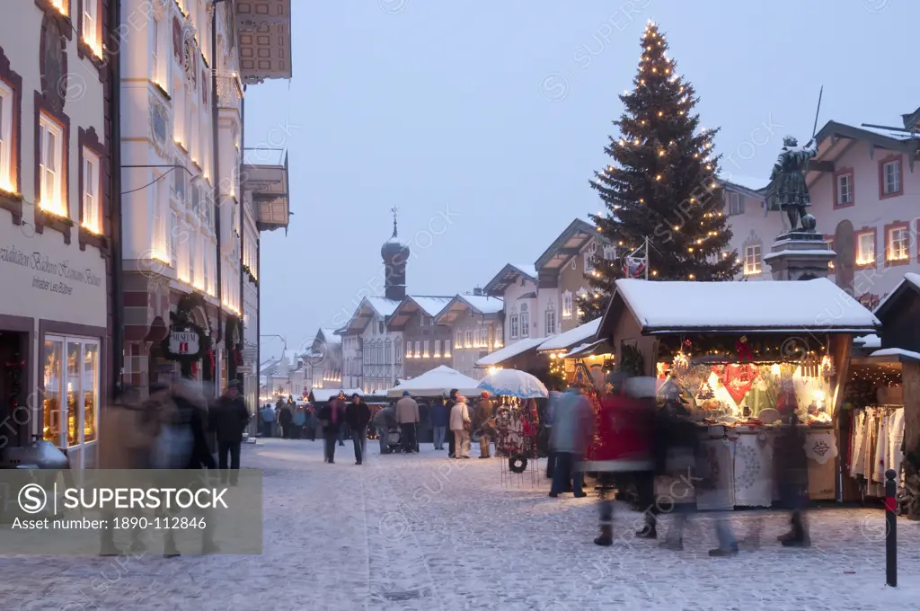 Christmas Market, Christmas tree with stalls and people at Marktstrasse at twilight in the spa town of Bad Tolz, Bavaria, Germany, Europe