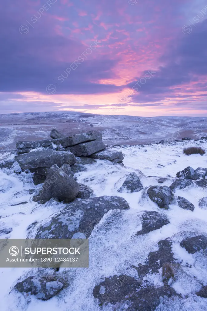 Beautiful sunrise in winter over a frozen snow covered moorland, Belstone Tor, Dartmoor, Devon, England, United Kingdom, Europe