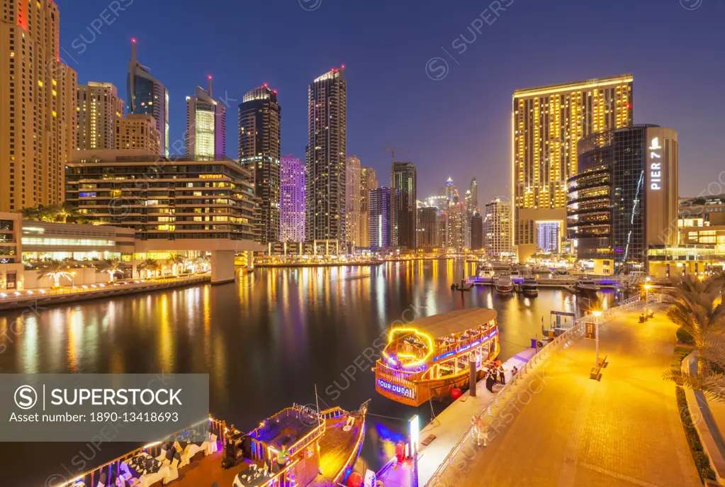 Dubai Marina skyline and tourist boats at night, Dubai City, United Arab Emirates, Middle East