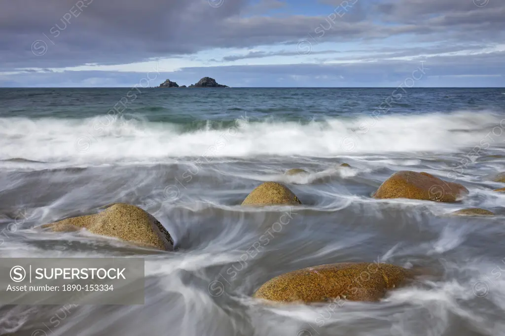 Waves swirl around rocks on Porth Nanven beach, Cornwall, England, United Kingdom, Europe