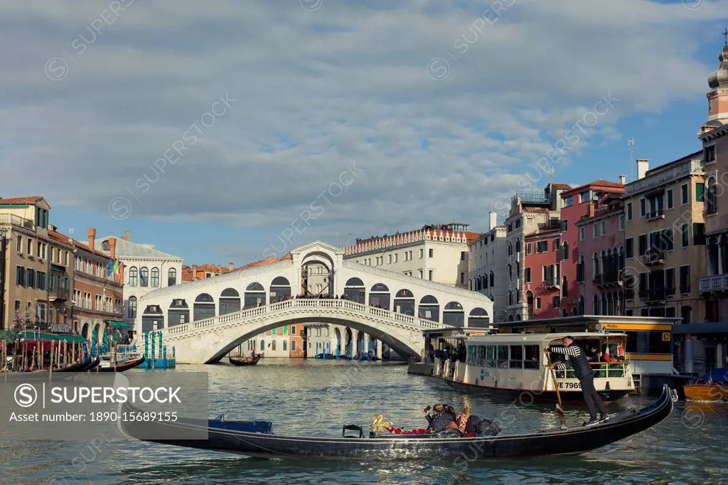 A gondola crossing the Grand Canal with a vaporetto and the Rialto Bridge beyond, Venice, UNESCO World Heritage Site, Veneto, Italy, Europe