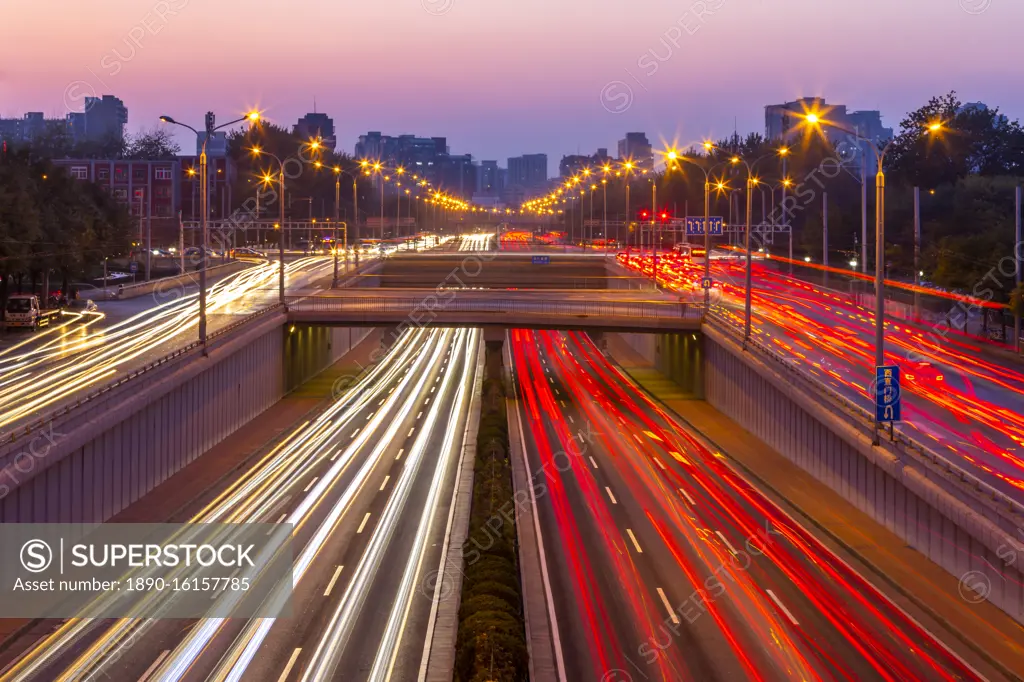 Traffic trail lights on major road near Beijing Zoo at dusk, Beijing, People's Republic of China, Asia