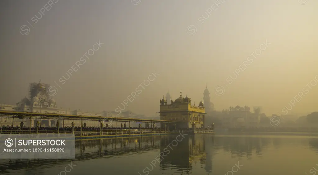 The Golden Temple at sunrise through fog, Amritsar, Punjab, India, Asia